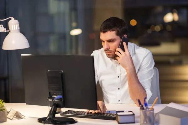 Business man calling on smartphone at night office — стоковое фото