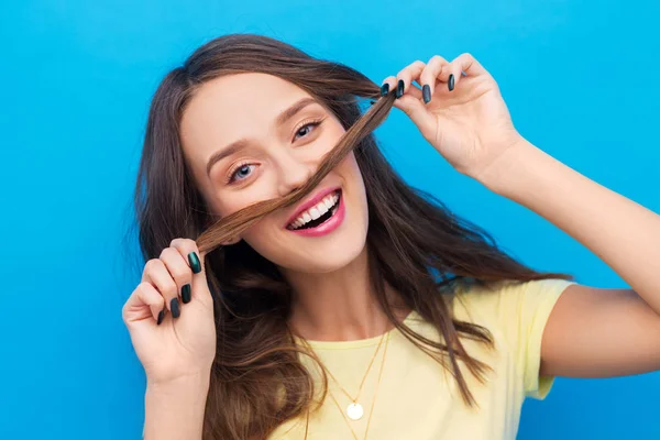 Gelukkig jonge vrouw maken snor met haar haren — Stockfoto