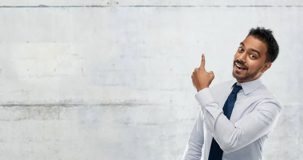 Indischer Geschäftsmann zeigt mit dem Finger auf Mauer — Stockfoto