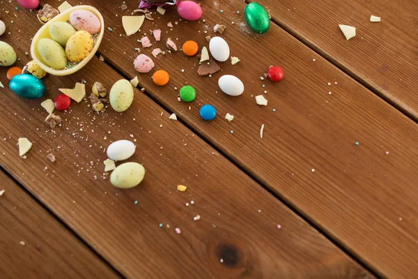 Choklad ägg och godis droppar på träbord — Stockfoto