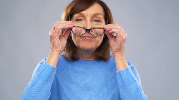 メガネを入れて満足している年配の女性の肖像画 — ストック動画