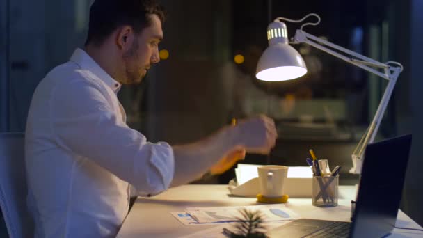 Hombre de negocios con papeles y café en la oficina nocturna — Vídeos de Stock