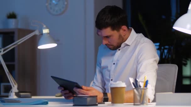 Бизнесмен с планшетным ПК работает в ночном офисе — стоковое видео