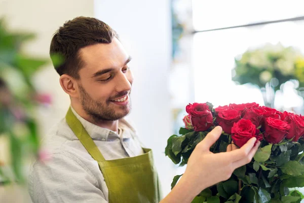 Floristería o vendedor estableciendo rosas rojas en floristería — Foto de Stock