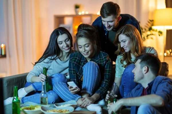 Amigos con smartphone viendo la televisión en casa —  Fotos de Stock