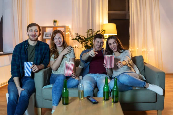 Přátelé s pivem a popcorn sledování televize doma — Stock fotografie