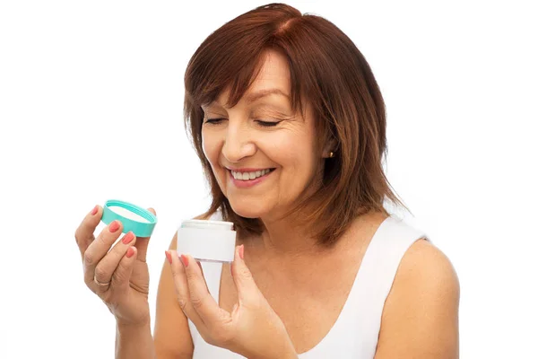 Sonriente mujer mayor con tarro de crema —  Fotos de Stock