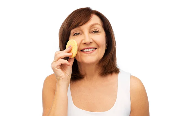 Woman cleaning face with exfoliating sponge — Stock Photo, Image