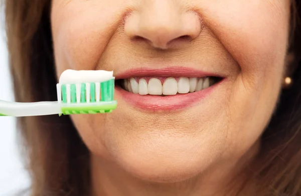 Ηλικιωμένη γυναίκα με οδοντόβουρτσα βουρτσίζει τα δόντια της — Φωτογραφία Αρχείου