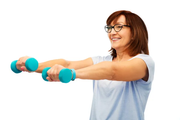 Sonriente mujer mayor con mancuernas haciendo ejercicio —  Fotos de Stock
