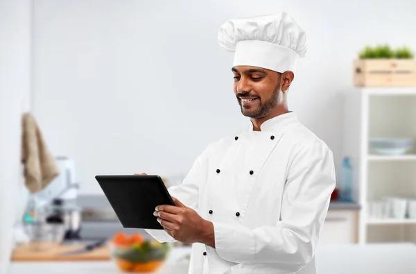 Szczęśliwy szef kuchni indyjskiej z komputera typu tablet w kuchni — Zdjęcie stockowe