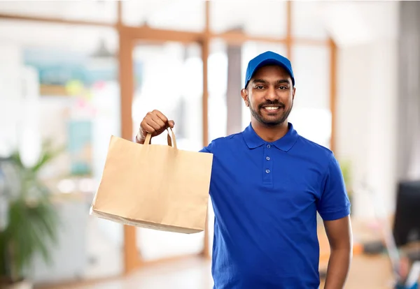 Delivery man with food in paper bag at office — Stock Photo, Image
