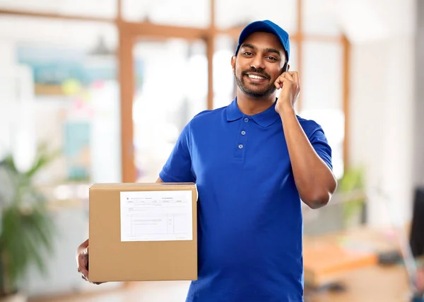 Repartidor indio con smartphone y caja de paquetes — Foto de Stock