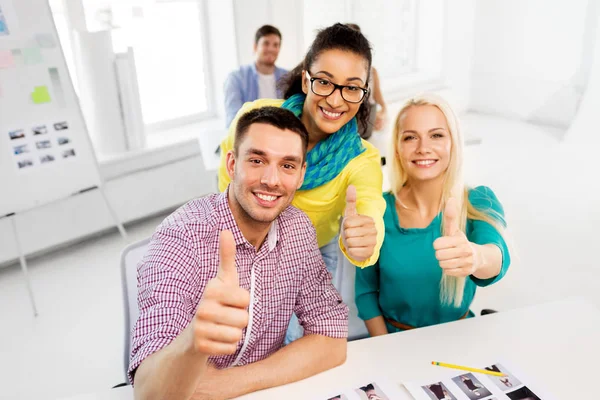 Equipo creativo mostrando pulgares hacia arriba en la oficina — Foto de Stock