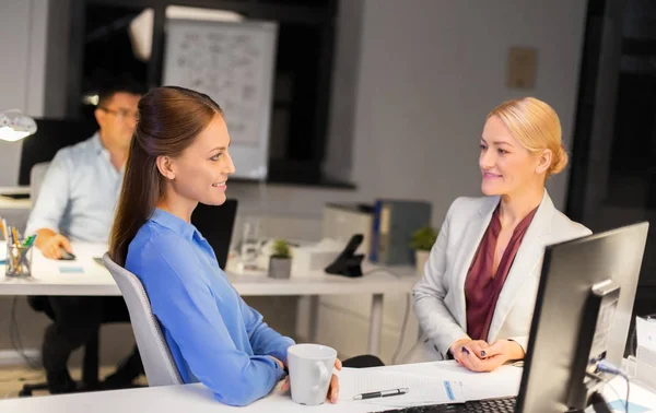 Forretningskvinner som drikker kaffe på nattkontoret – stockfoto