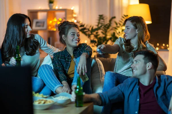 Vänner med drycker och snacks på tv hemma — Stockfoto