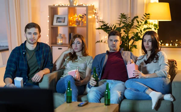 Amigos com cerveja e pipocas assistindo tv em casa — Fotografia de Stock