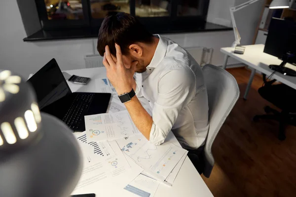 Hombre de negocios con papeles trabajando en la oficina nocturna — Foto de Stock