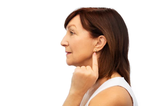 Senior woman pointing to her golden earring — Stock Photo, Image