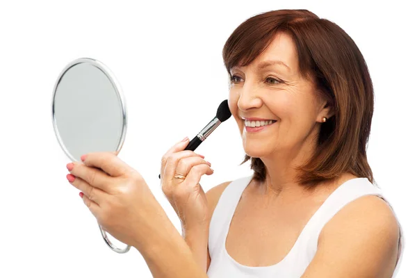 Senior woman with mirror and make up blush brush — Stock Photo, Image