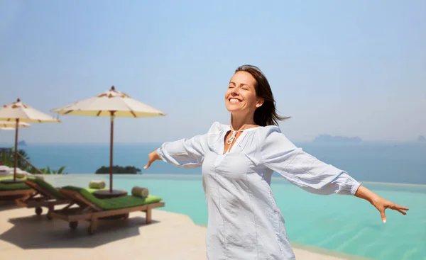 Felice donna godendo di sole oltre piscina bordo infinito — Foto Stock