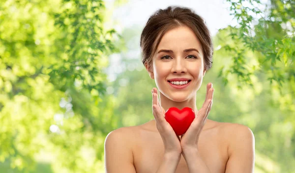 Szép mosolygó nő gazdaság piros szív — Stock Fotó