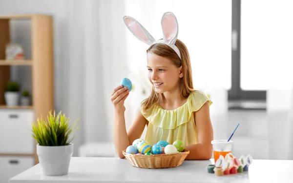 Felice ragazza con uova di Pasqua colorate a casa — Foto Stock