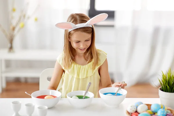 Ragazza colorazione uova di Pasqua da colorante liquido a casa — Foto Stock