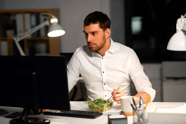 Podnikatel v počítači jíst v noci kancelář — Stock fotografie