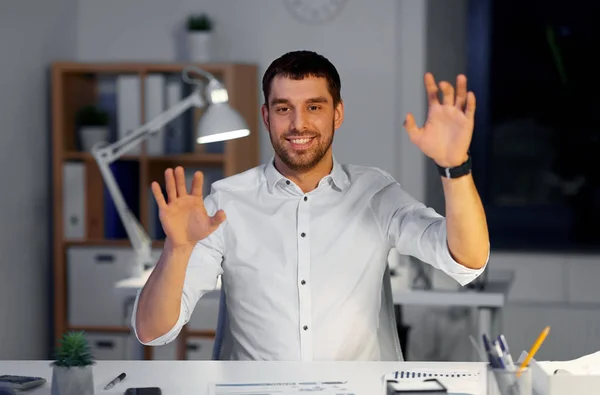 Empresário usando gestos no escritório noturno — Fotografia de Stock