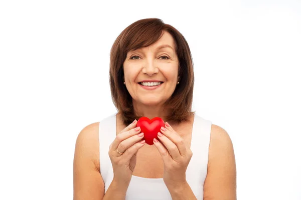 Gülümseyen kadın kıdemli holding kırmızı kalp portresi — Stok fotoğraf