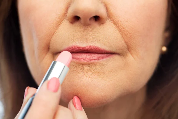 Primo piano della donna anziana che applica il rossetto — Foto Stock