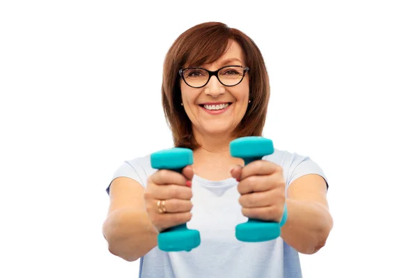 Smiling senior woman with dumbbells exercising — Stock Photo, Image