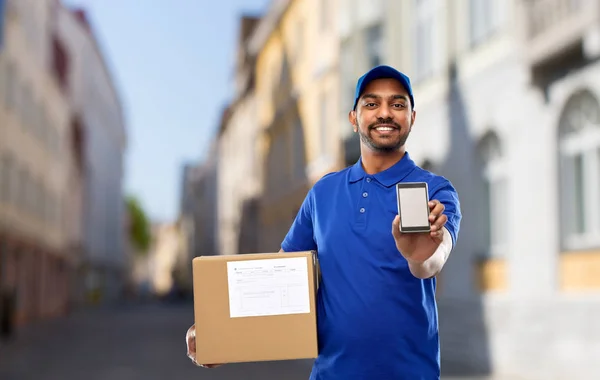 Delivery man with smartphone and parcel in city Stock Photo