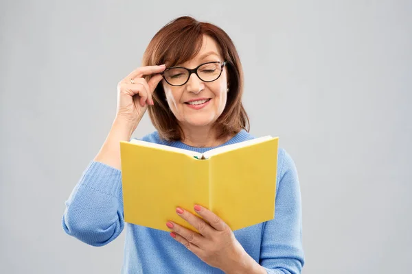 Retrato de mujer mayor en gafas libro de lectura — Foto de Stock