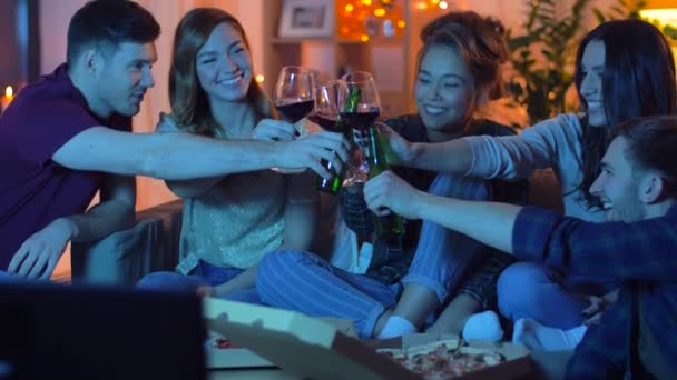 Друзья с напитками и пиццей смотреть телевизор дома — стоковое видео