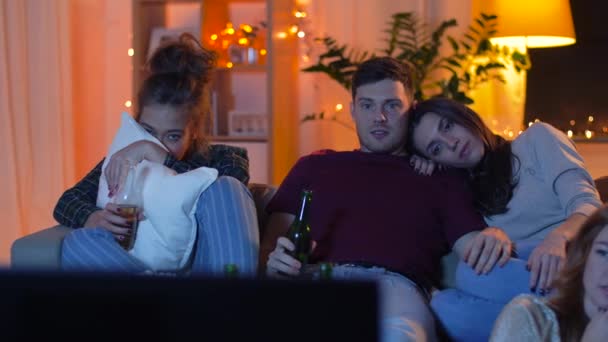 Друзі з пивом і попкорном дивитися телевізор вдома — стокове відео