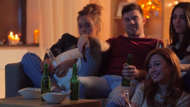 Amigos com bebidas e lanches assistindo tv em casa — Vídeo de Stock