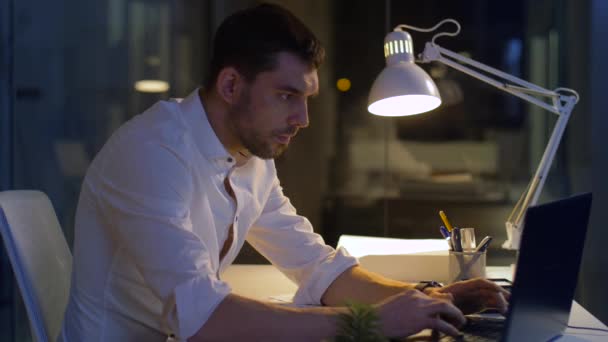 Бизнесмен с ноутбуком работает в ночном офисе — стоковое видео