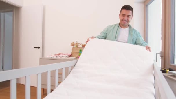 Otec uspořádání dětské postýlky s matrací doma — Stock video