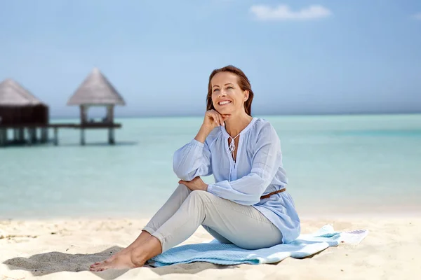 Yaz plaj üzerinde oturan mutlu kadın — Stok fotoğraf