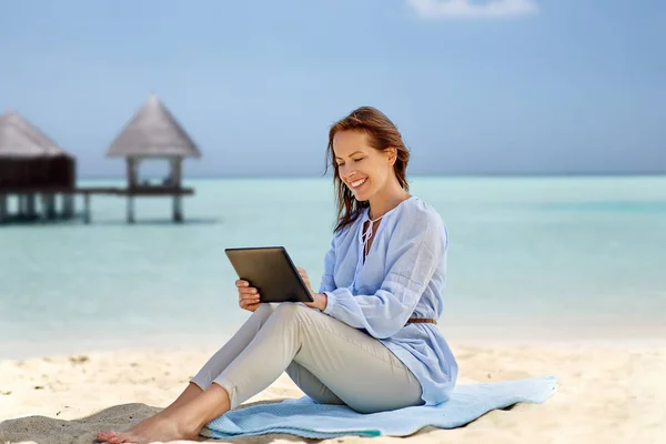 Felice donna sorridente con tablet pc sulla spiaggia estiva — Foto Stock