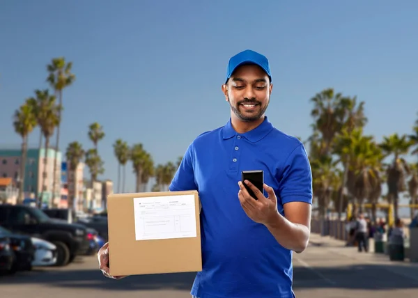 Indian delivery man with smartphone and parcel box — Stock Photo, Image