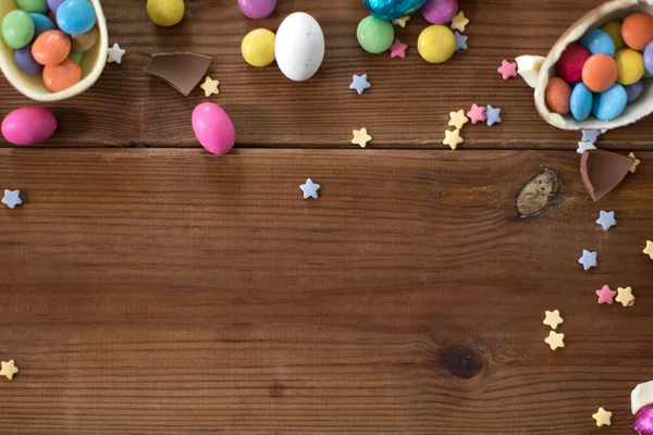 Huevos de chocolate y gotas de caramelo en mesa de madera — Foto de Stock