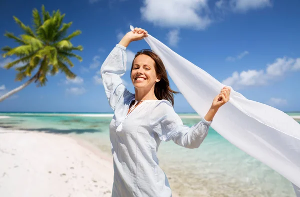 Glückliche Frau mit Tuch, das im Wind am Strand weht — Stockfoto