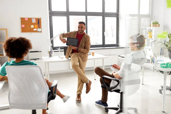 Homem mostrando tablet pc para a equipe criativa no escritório — Fotografia de Stock