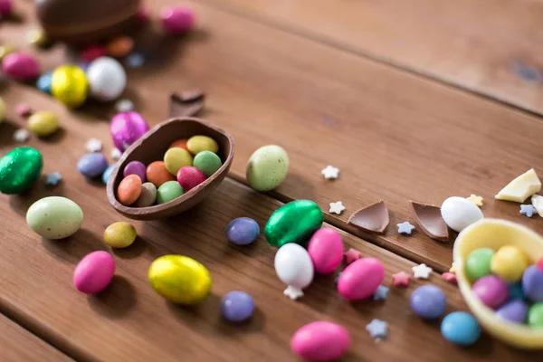 木桌上的巧克力蛋和糖果滴 — 图库照片