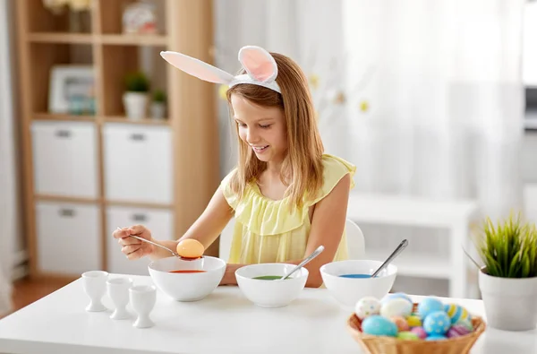 Ragazza colorazione uova di Pasqua da colorante liquido a casa — Foto Stock