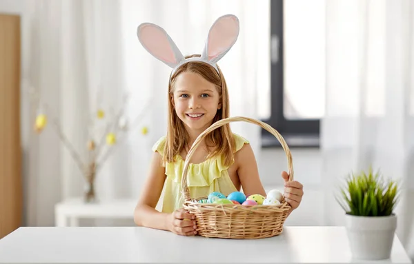 Щаслива дівчина з кольоровими великодніми яйцями вдома — стокове фото