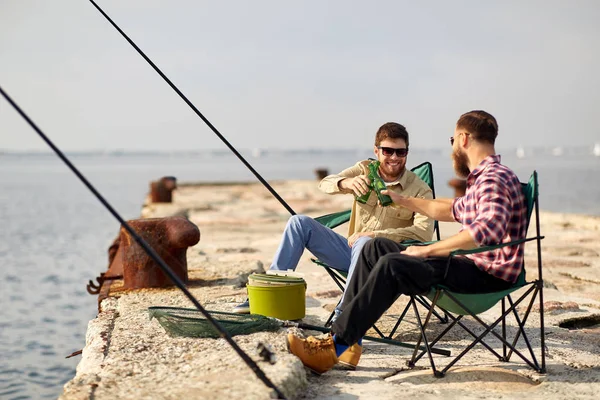 Amigos felizes pesca e beber cerveja no cais — Fotografia de Stock